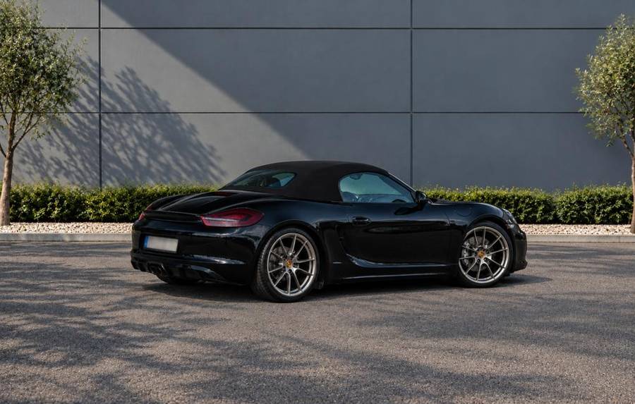 Porsche Boxster noire capote fermée, vue arrière trois quarts